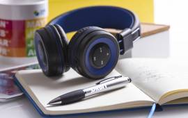 Duo de goodies professionnels Copytop : un casque bluetooth high-tech et un stylo élégant, tous deux personnalisés avec un logo d'entreprise, illustrant le potentiel marketing des objets promotionnels