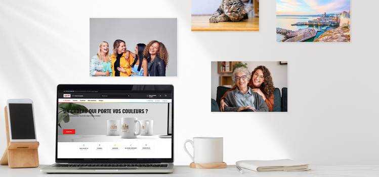 Mur décoré de photos imprimées de haute qualité à côté d'un ordinateur affichant le site web de COPYTOP, illustrant la facilité d'imprimer des photos en ligne pour divers usages professionnels