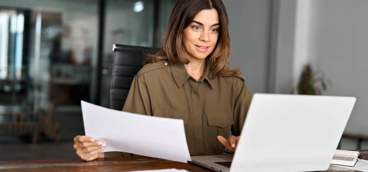 Femme souriante devant son ordinateur, passant une commande sur le site COPYTOP, avec une indication de livraison rapide en 4h, illustrant la satisfaction et l'efficacité de l'impression en ligne